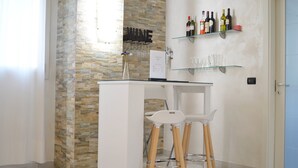 A modern kitchen with a stone accent wall, a wine rack, and a bar area with stools. - La Villa (Montagnana)