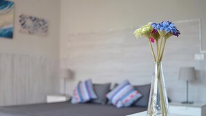 A clear glass vase with flowers on a white table in a hotel room. - La Villa (Montagnana)