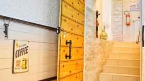A staircase with a wooden cabinet and a sign advertising fresh brewed coffee. - La Villa (Montagnana)