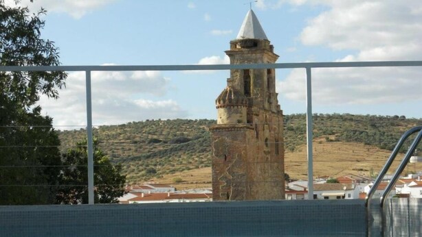 Vista de una piscina con una torre de piedra al fondo.