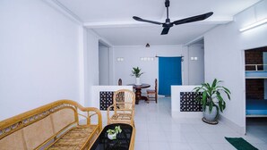 Una sala de estar moderna con un sofá, sillas, una mesa de centro y un ventilador de techo.