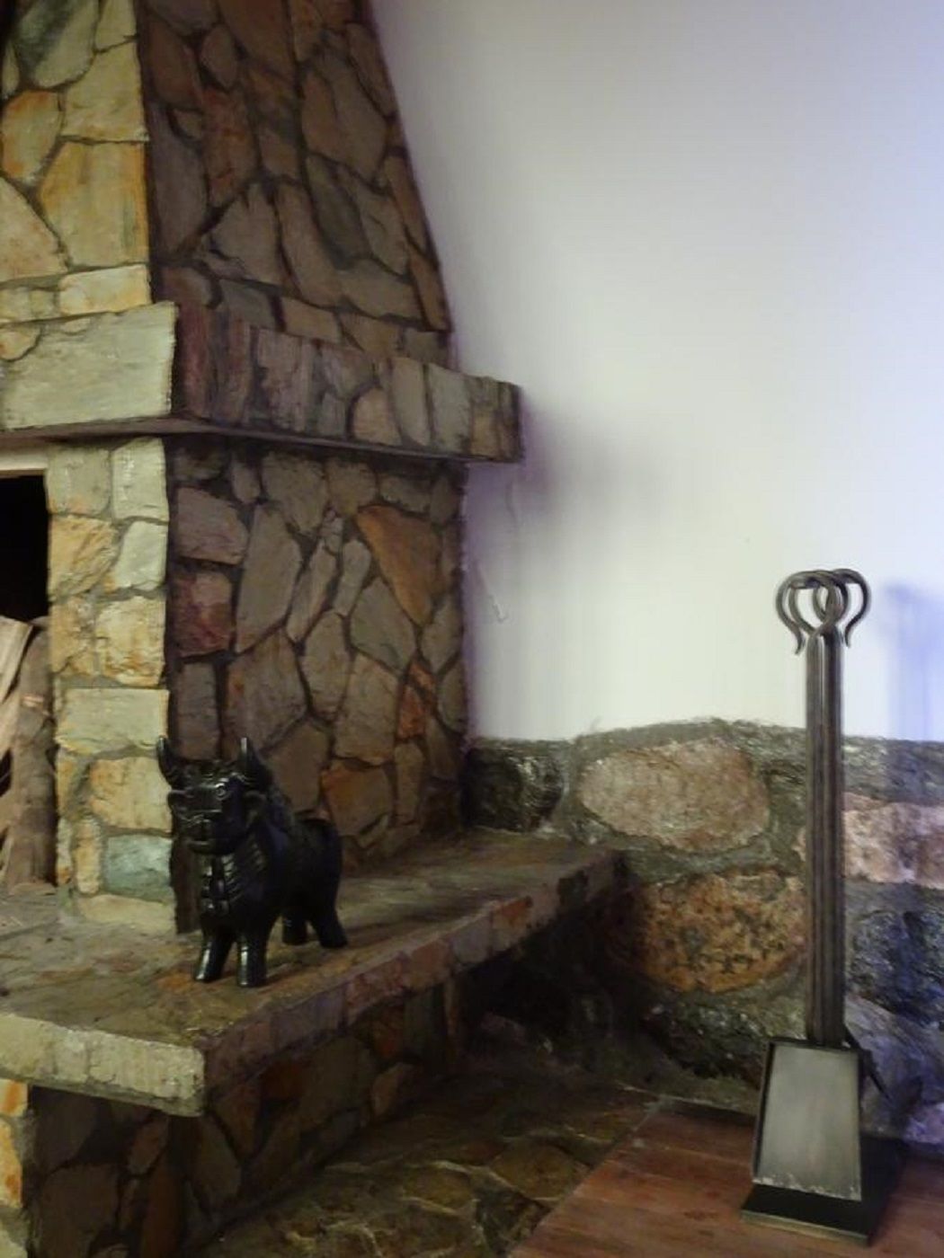 A stone fireplace with a decorative metal sculpture of a horse.
