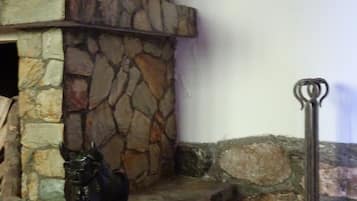 A stone fireplace with a decorative metal sculpture of a horse.