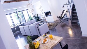 A modern dining area with a wooden table, black chairs, and a fruit bowl. - Antichambre (Nîmes)