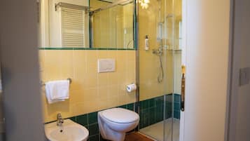 A bathroom with a toilet, sink, and shower.