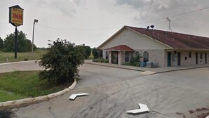A motel with a red roof and a signboard.