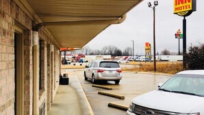 A motel with a covered parking area, a visible sign for 'Rest Inn Motel', and a 'Jackson' car rental sign. - Rest Inn Motel (Palestine)