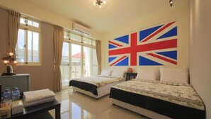 A hotel room with two beds, a table with toiletries, and a large British flag on the wall. - Star to travel B&B (Hengchun)