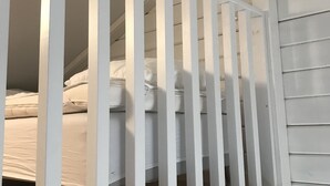 A white wooden staircase with a railing leading to a bedroom with a bed and pillows. - Hills Loft Cottage with Sauna (Gränna)