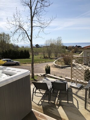 A hot tub with two chairs, a view of a residential area, and a clear sky. - Hills Loft Cottage with Sauna (Gränna)