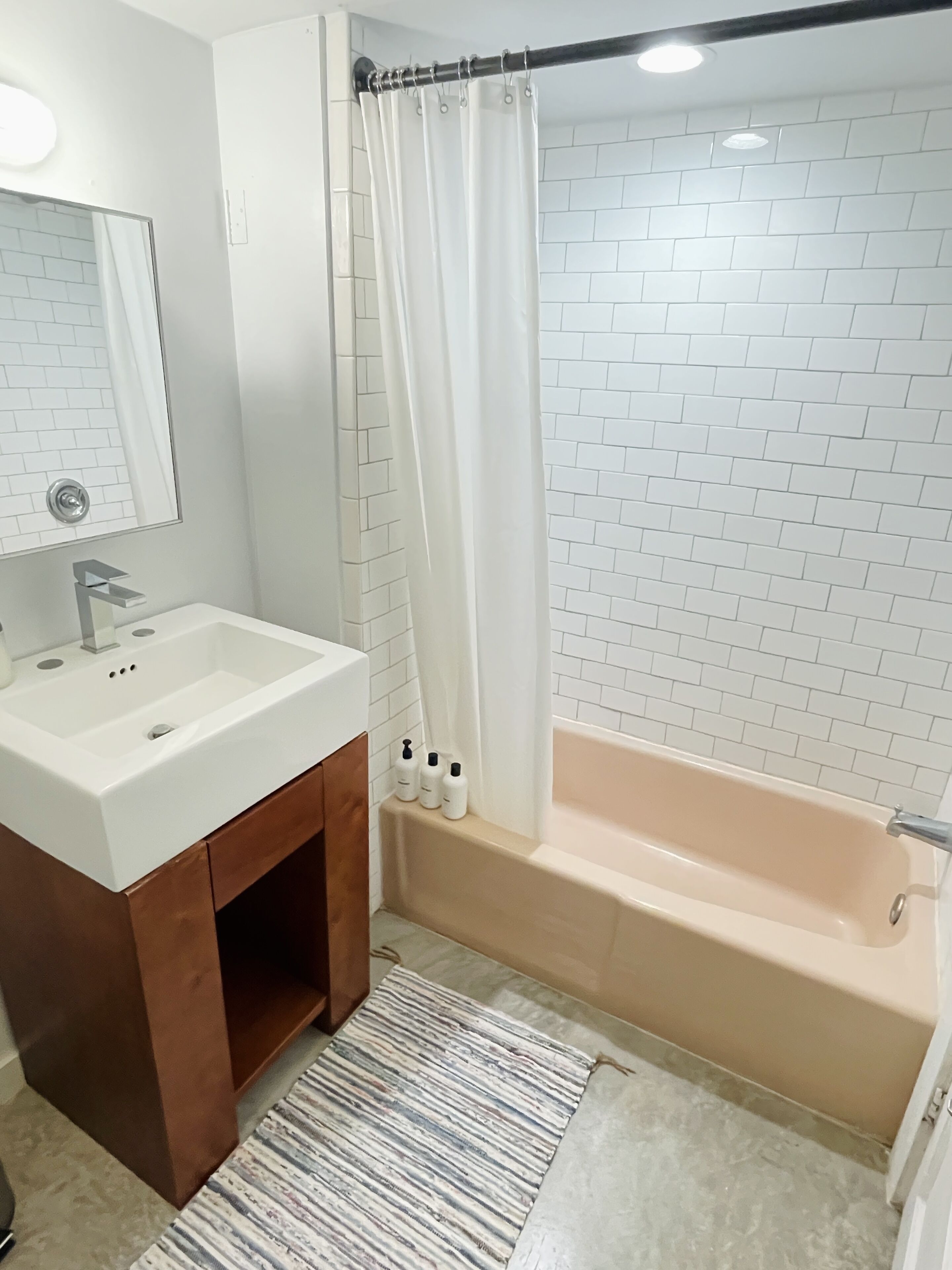 Un bagno con lavandino, mobile lavabo e vasca da bagno bianchi.