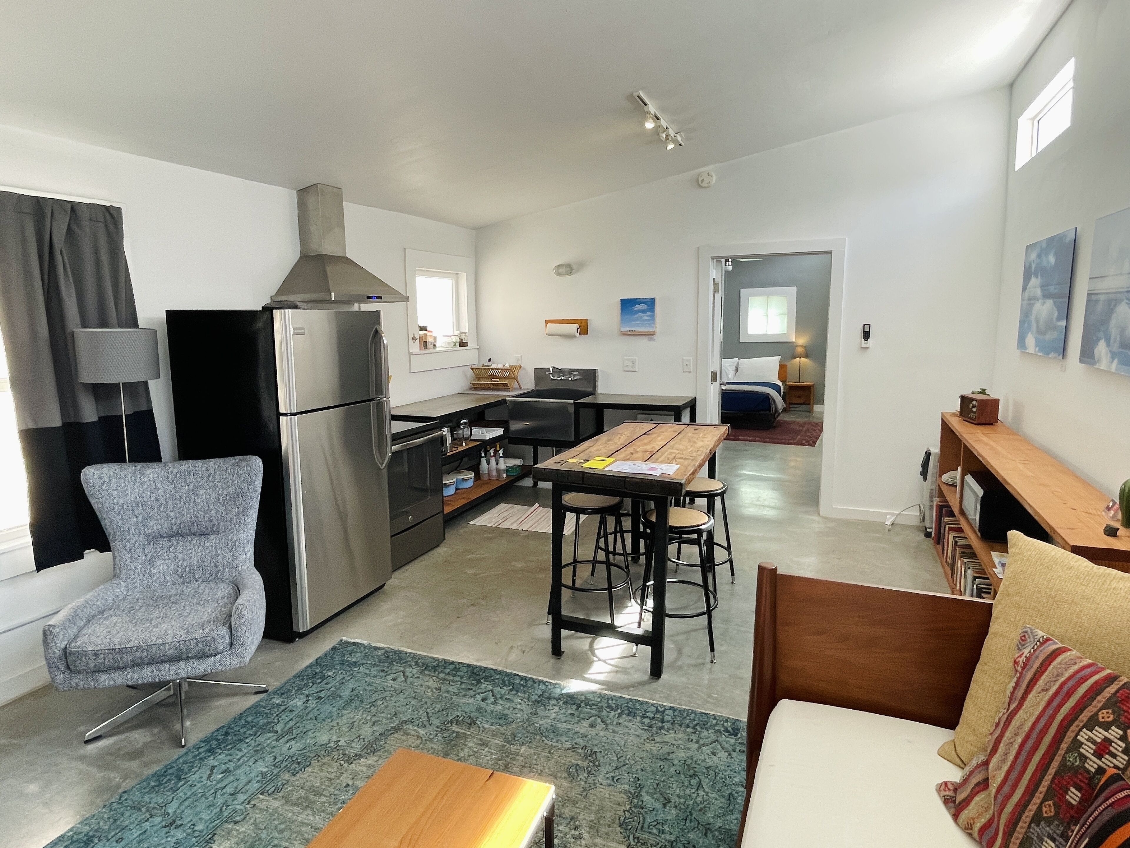 Un espacio habitable compacto con kitchenette, comedor y dormitorio.