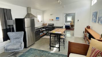 Un espacio habitable compacto con kitchenette, comedor y dormitorio.