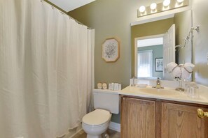 A bathroom with a toilet, sink, and shower curtain.