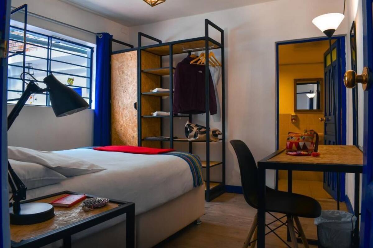Ein gemütliches Schlafzimmer mit Bett, Nachttisch, Schreibtisch, Stuhl und einem Einbauschrank mit Regalen.
