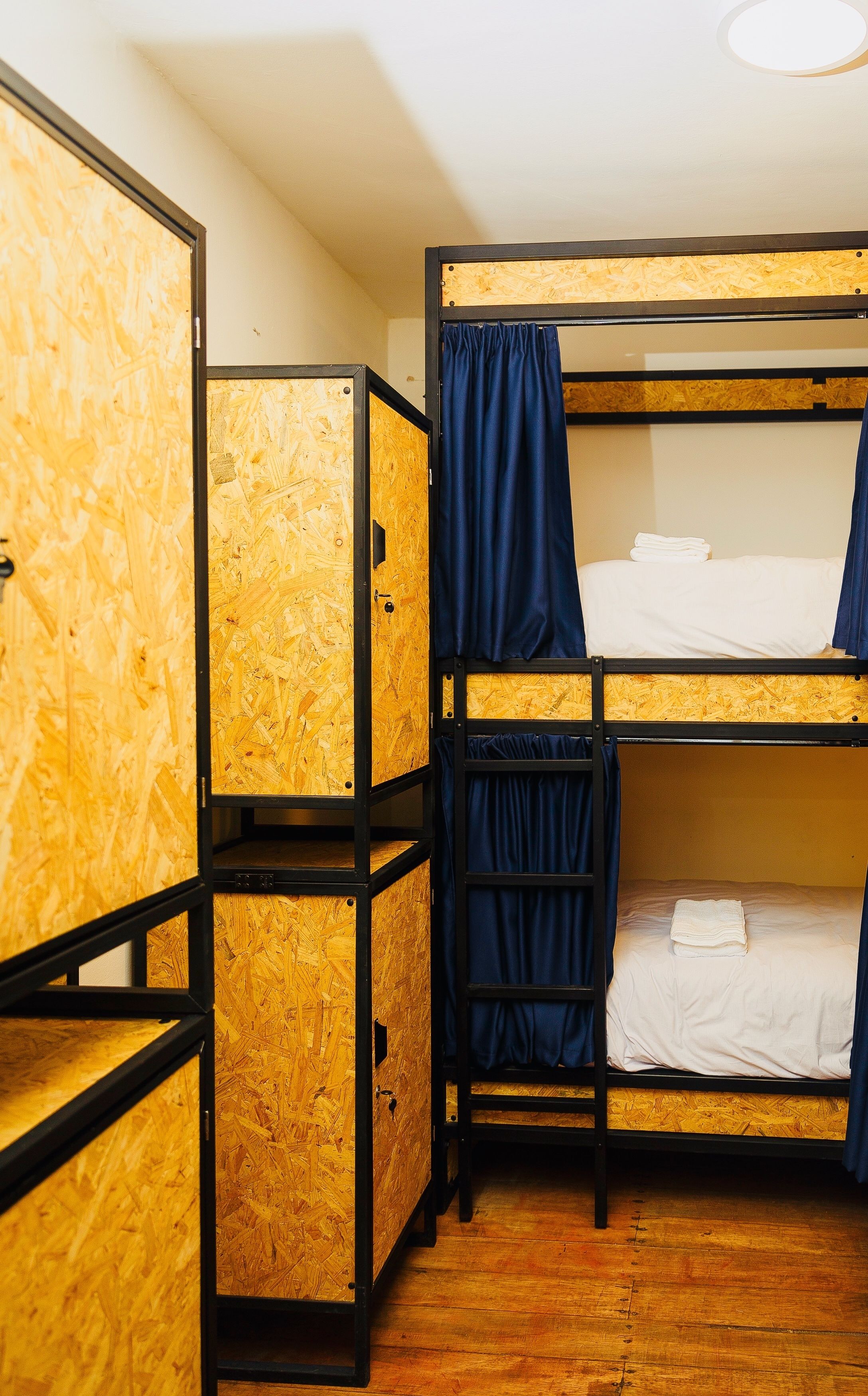 A bunk bed room with wooden bunk beds and a wardrobe.