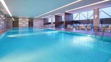 Una piscina techada, sillones reclinables de piscina