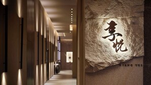 A corridor with a stone wall featuring carved Chinese characters and the name "Xiang Yue". - Hyatt Regency Shanghai Jiading (Shanghai)