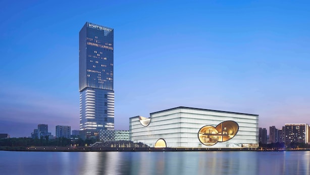 A modern hotel with a distinctive circular design element and a tall adjacent skyscraper. - Hyatt Regency Shanghai Jiading (Shanghai)