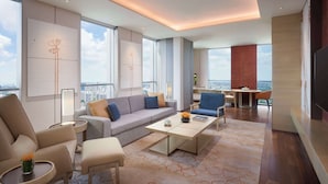 A modern living room with a sofa, chairs, a coffee table, and a city view through large windows. - Hyatt Regency Shanghai Jiading (Shanghai)