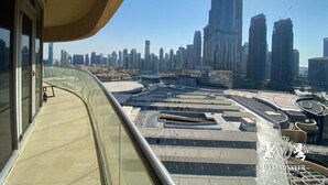 Un edificio alto con un balcón curvo que da a una vista panorámica de la ciudad.