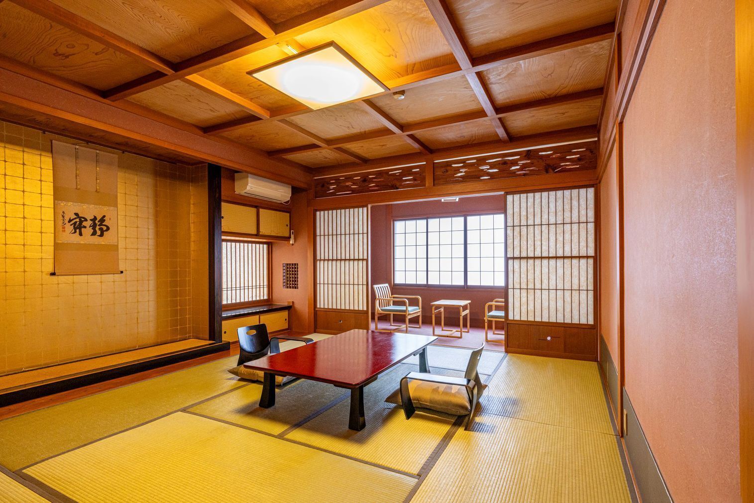 Una habitació japonesa tradicional amb tatami, una taula baixa i portes corredisses.