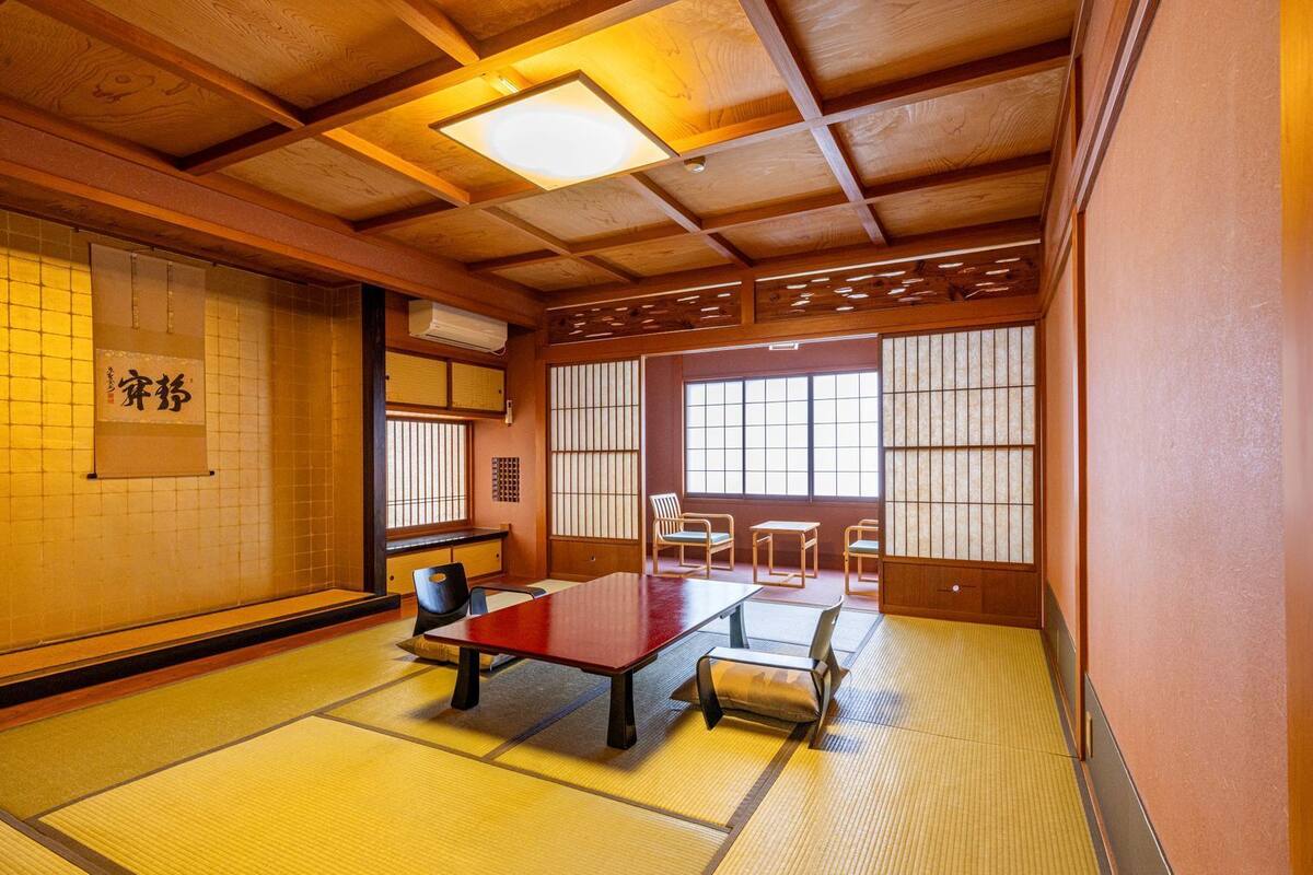 A traditional Japanese room with tatami flooring, a low table, and sliding doors.