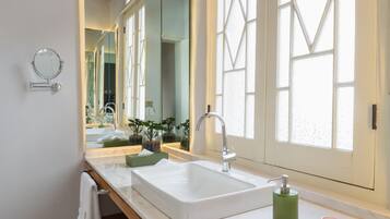 Une salle de bain moderne avec un grand miroir, un lavabo blanc et un meuble-lavabo en bois.