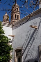 Un edificio con fachada blanca, una ventana y una puerta.