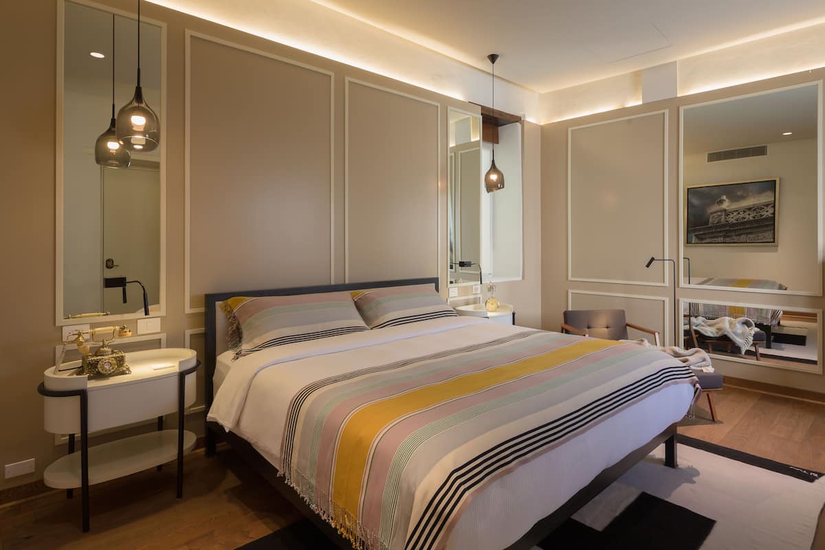 Una camera da letto moderna con un letto grande, comodini, uno specchio e un tavolino.