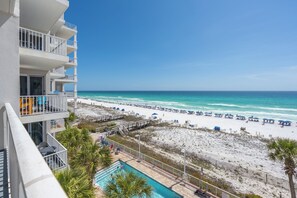 Ein Hotel direkt am Strand mit Pool, Strandliegen und freiem Blick auf das Meer.