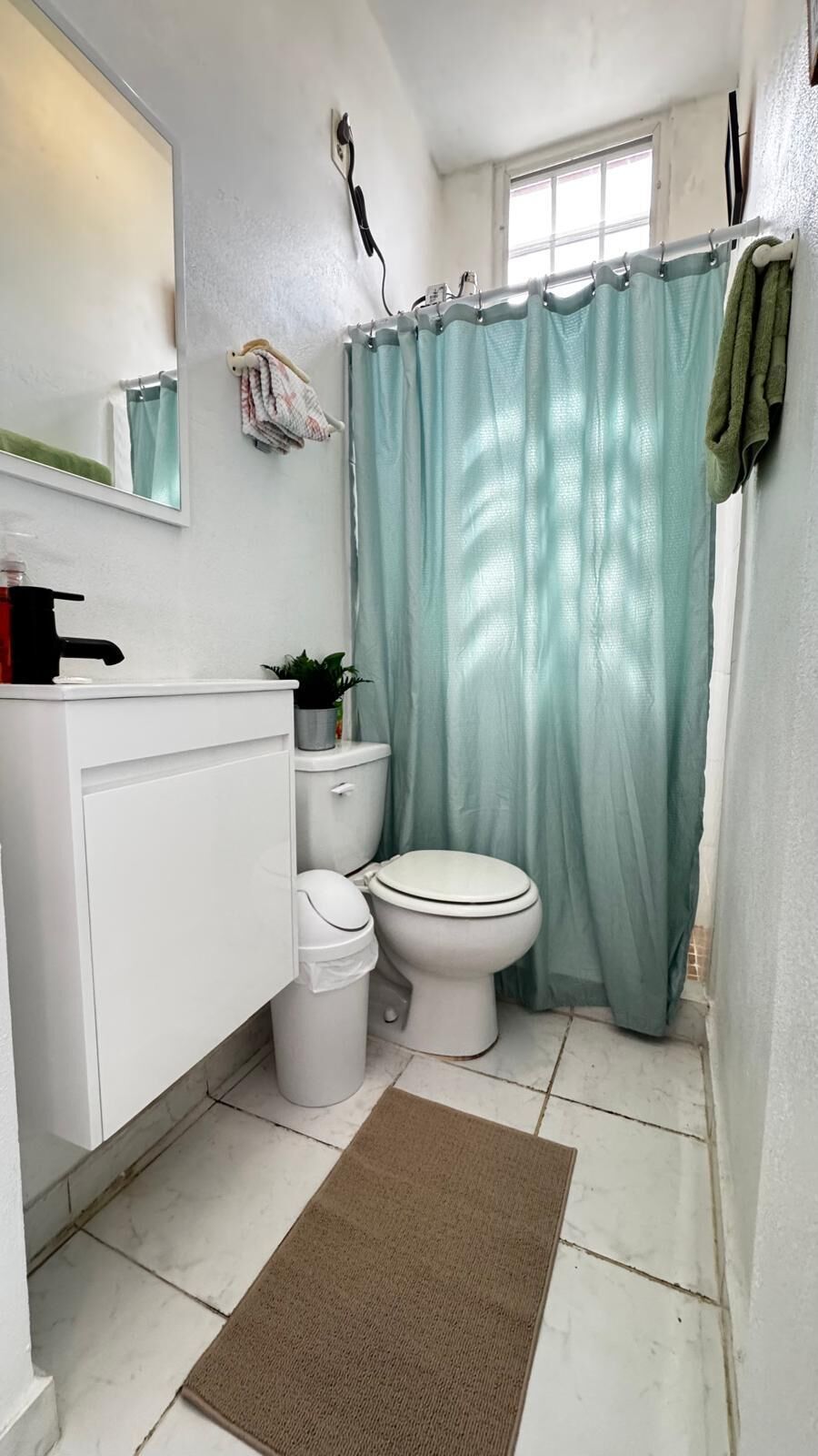Un bagno con il water, lavandino e tenda della doccia.