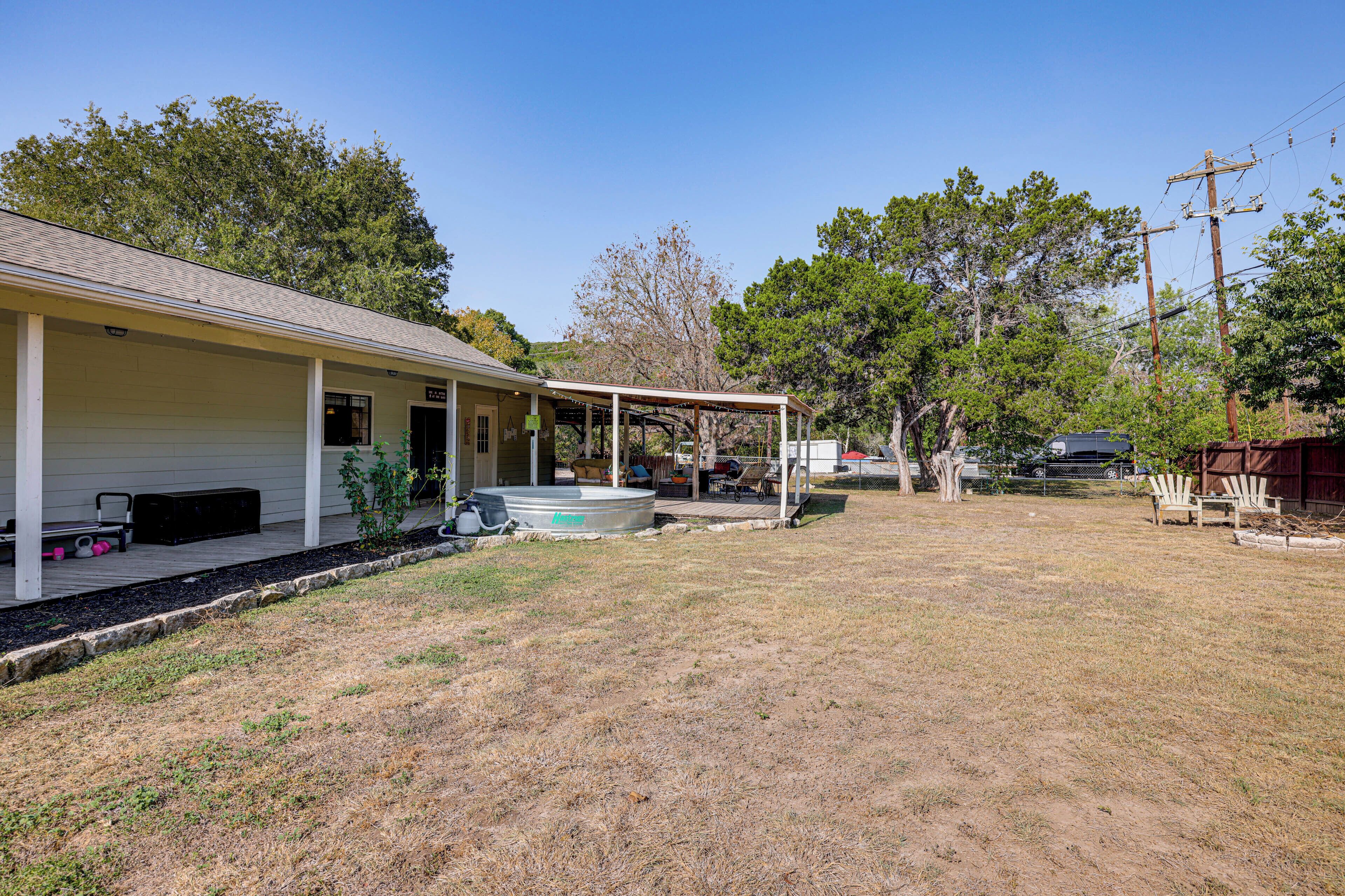 A single-story house with a covered porch, a swimming pool, and a fenced backyard.