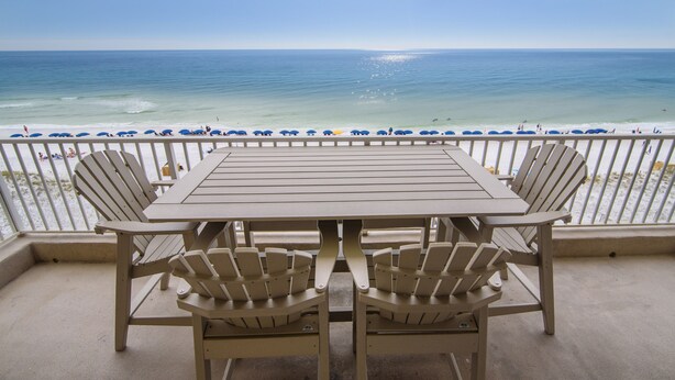A balcony with a table and chairs overlooking a beach. - Inn at Crystal Beach 506 * Gulf Front with Beach Chair Set. Onsite dining! (Destin)