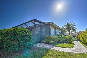 A modern house with a glass-enclosed porch, surrounded by well-maintained greenery and a paved pathway. - < 1 Mi to Beach w/ Pool & Lanai: Marco Island Home (Marco Island)