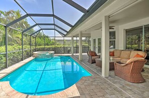 A covered outdoor swimming pool with a hot tub, wicker furniture, and a view of lush greenery. - < 1 Mi to Beach w/ Pool & Lanai: Marco Island Home (Marco Island)