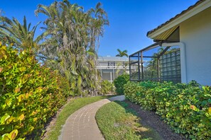 Stroll through lush gardens to a modern building with large windows and clean lines.