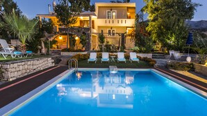 A swimming pool with lounge chairs and a building in the background. - Villa Elisa, View+Hidden in Trees! (Perama)