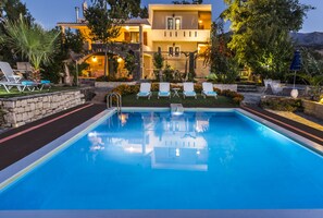 Una piscina al aire libre, sillones reclinables de piscina