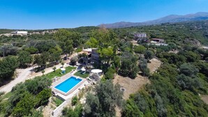 An aerial view of a property with a swimming pool, multiple buildings, and surrounding greenery. - Villa Elisa, View+Hidden in Trees! (Perama)