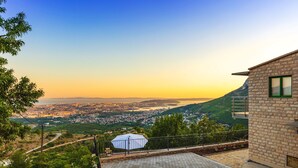 Un bâtiment en pierre offrant une vue sur la ville et les collines.