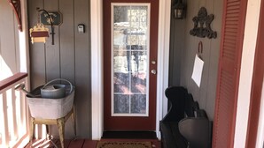 A front door with a red frame and a glass panel, a mailbox, a small step leading to the door, and a wooden bench outside. - Charming Victorian Farmhouse, Privacy, Wi-FI , 5 min to Durango (Durango)