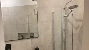 Une salle de bain moderne avec un grand miroir, un lavabo, une douche et une baignoire.