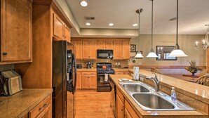 A modern kitchen with wooden cabinets, stainless steel appliances, and pendant lighting. - Southwind Seven Springs Home on Ski Slopes! (Champion)