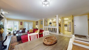 A spacious living room with a dining area, yellow walls, and a kitchen in the background. - Nicely Updated First Floor Villa! (Hilton Head)