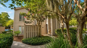 A two-story house with a front porch, a wooden fence, and a well-maintained garden.