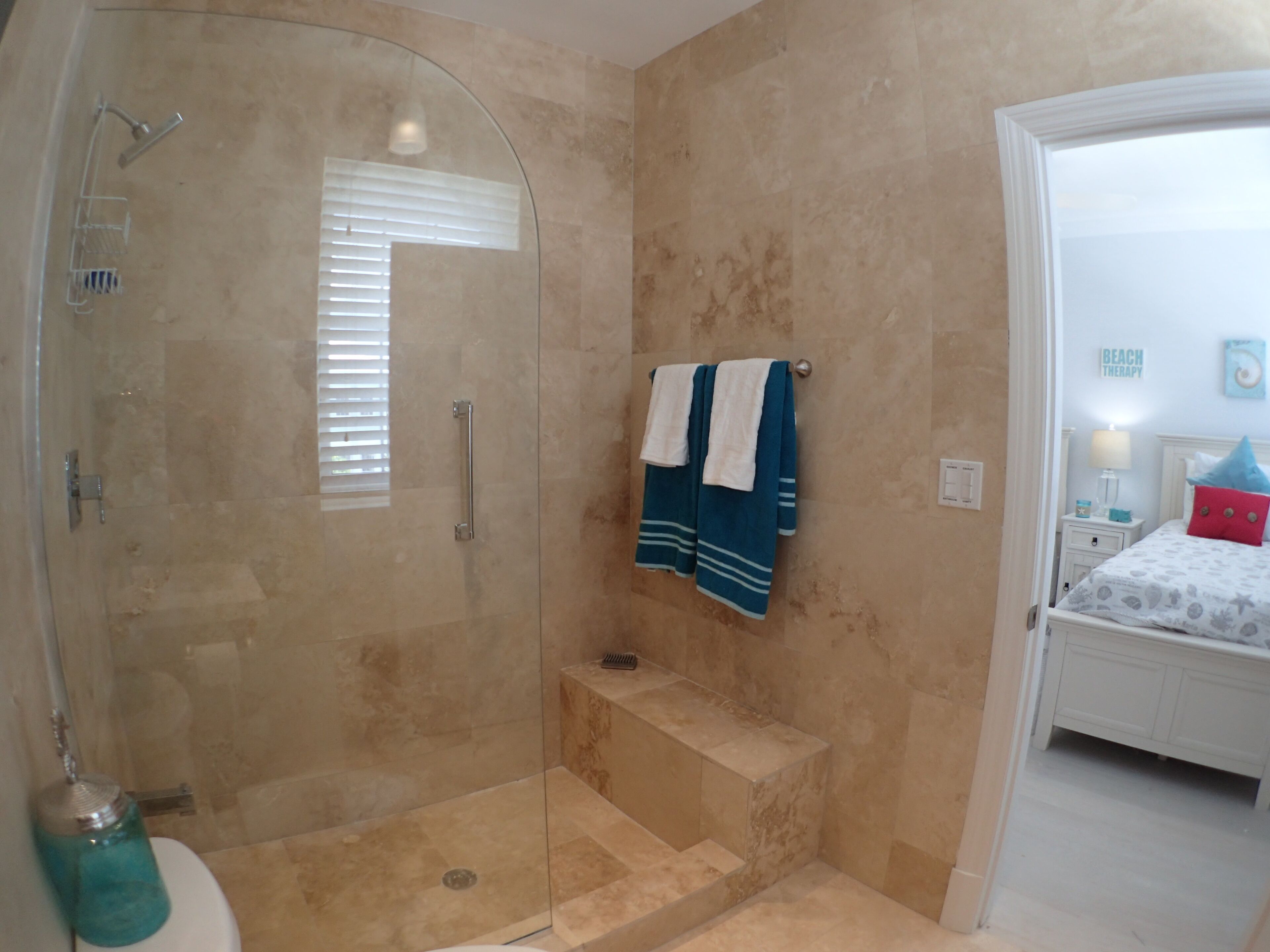 Un baño con ducha de vidrio, inodoro y lavamanos.