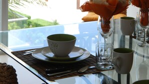 Una mesa de comedor con vistas al exterior, que incluye una terraza de madera y follaje.