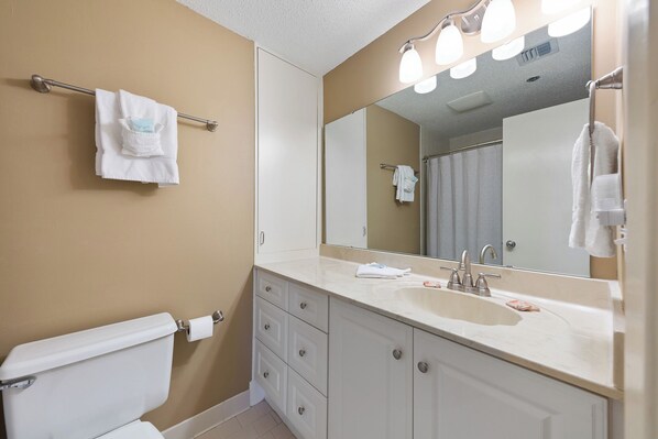 Une salle de bain avec des toilettes, un lavabo et un miroir.