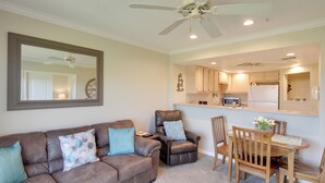 A living room with a brown leather sofa, a dining table with chairs, a kitchen area, and a ceiling fan. - Lake Havasu Getaway w/ Golf Course & Lake Views! (Lake Havasu City)